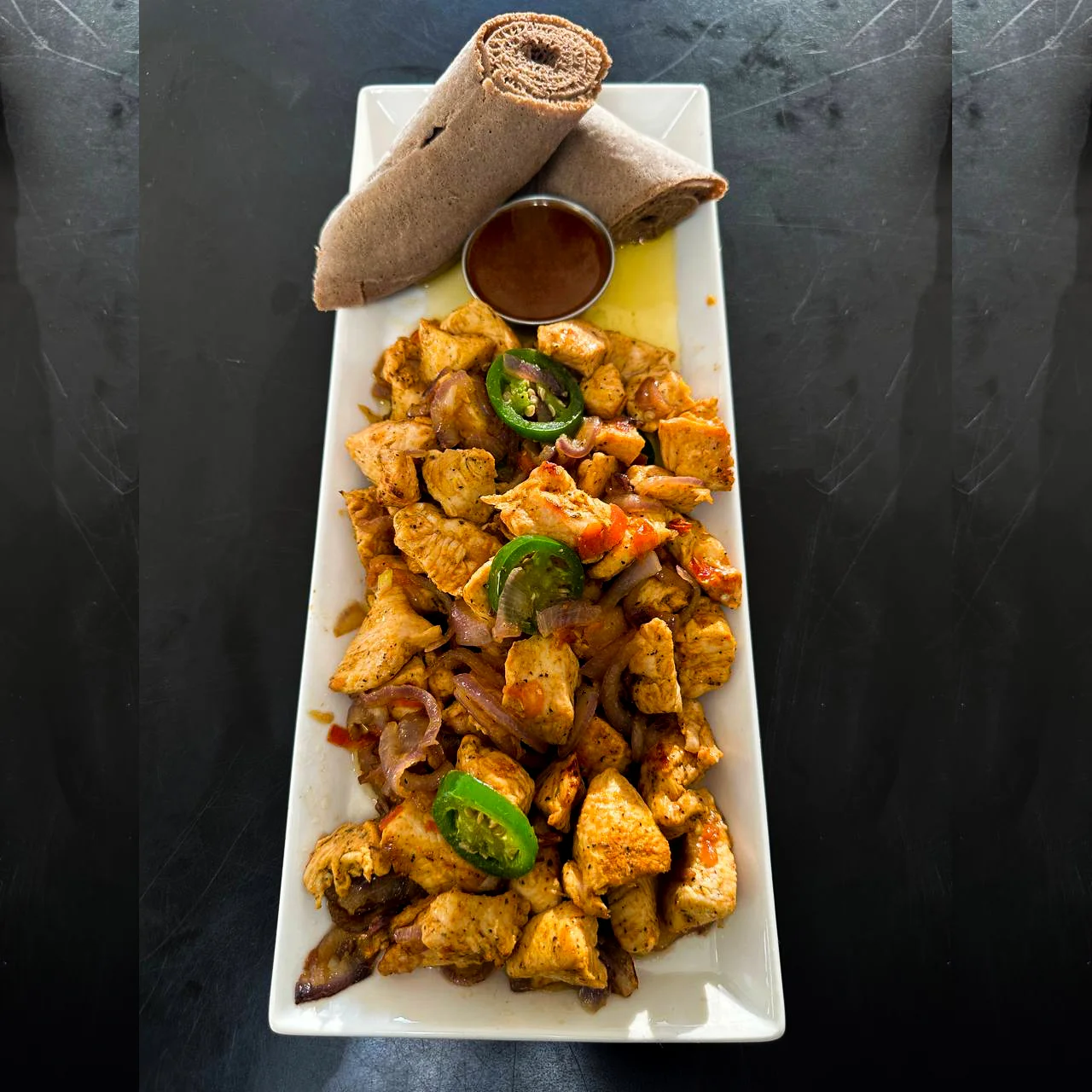 Chicken tibs served with injera
