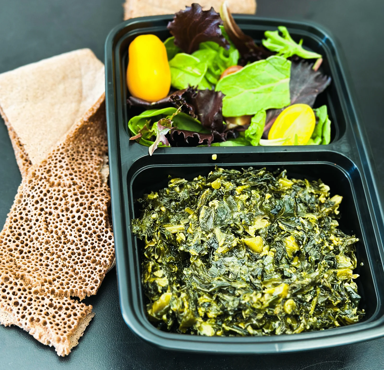Gomen collard greens with injera and salad
