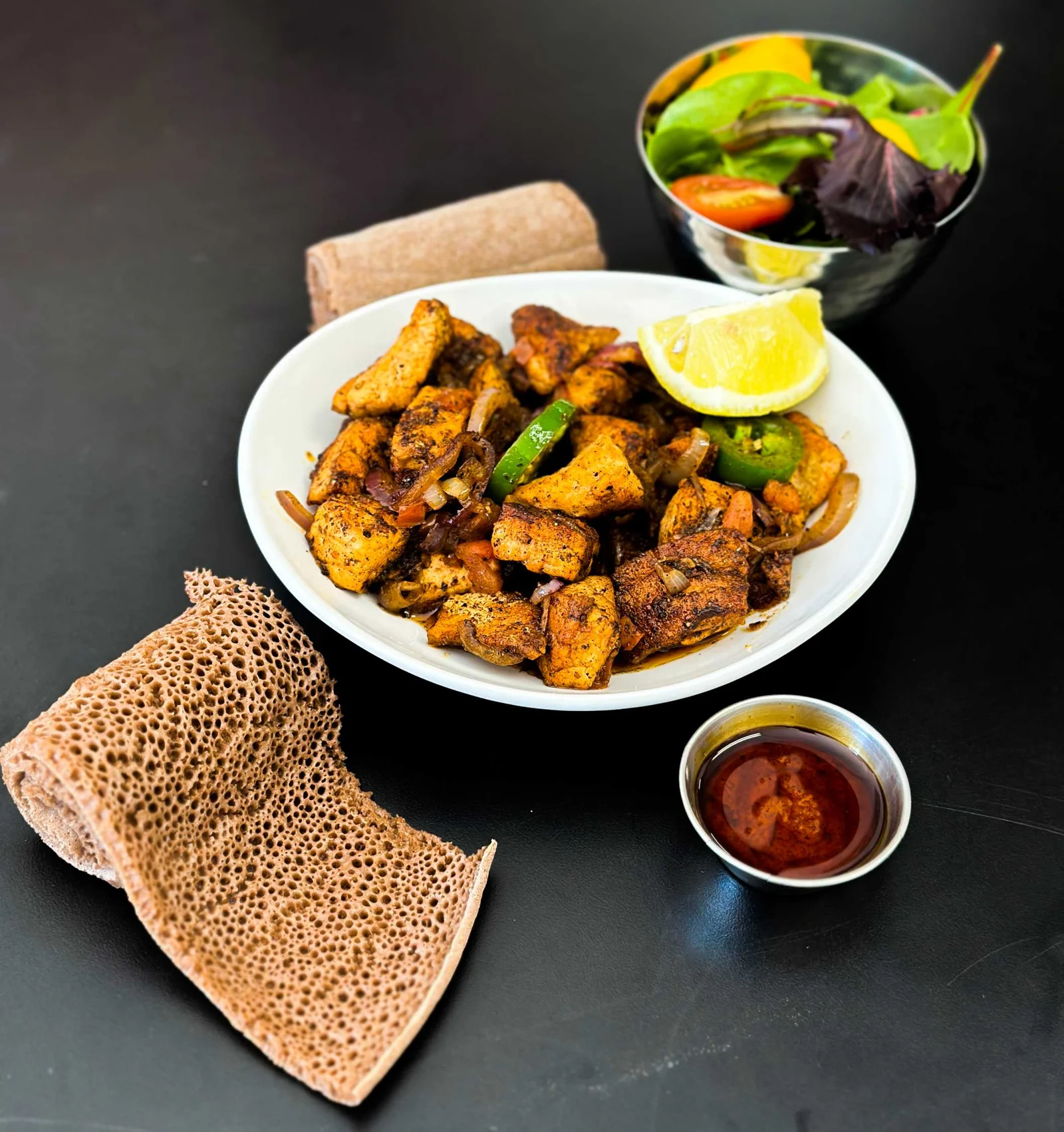 GIHON meat sampler with tibs, injera, salad, and sauce