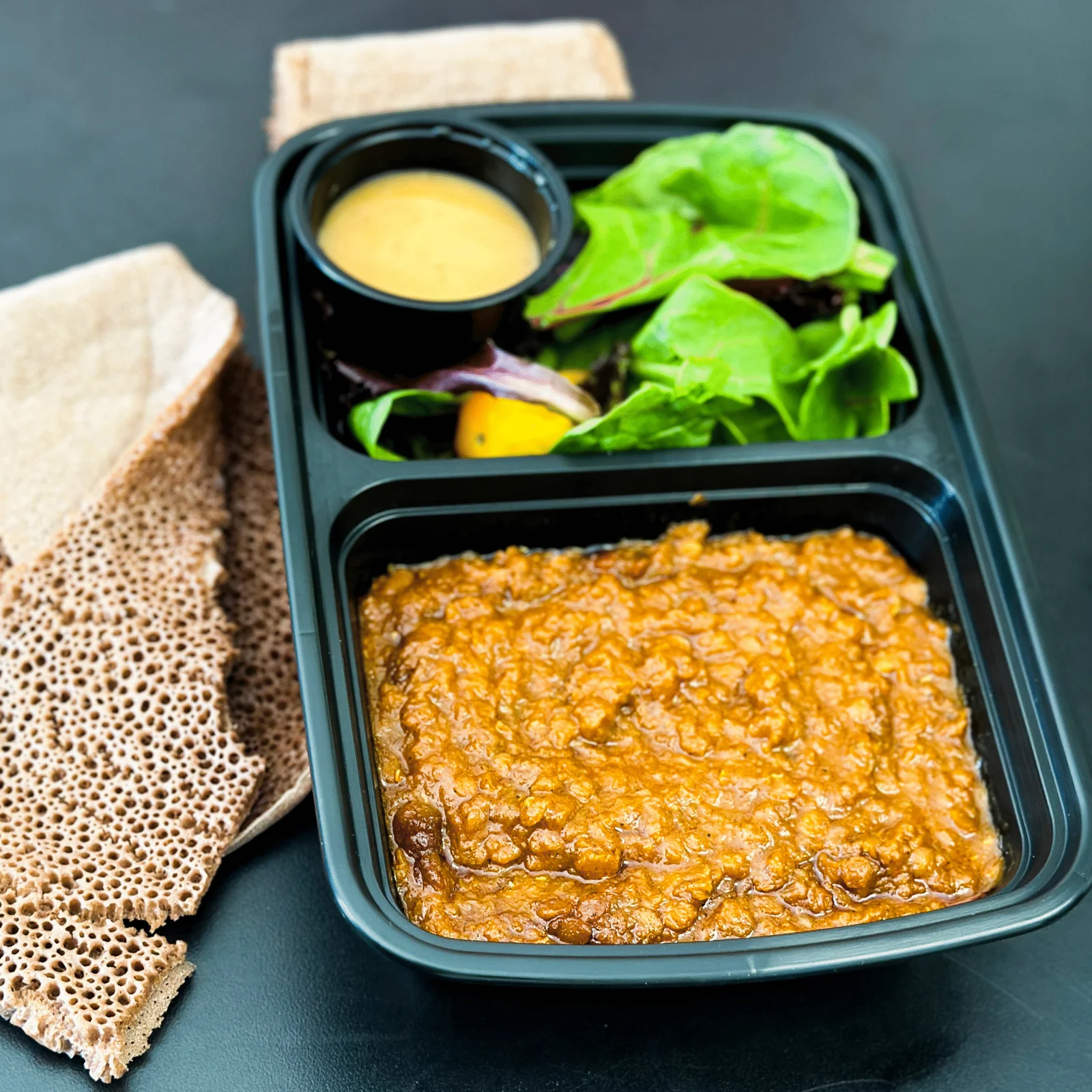 Misir red lentil stew with injera and salad